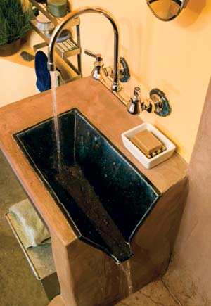 Water flows from the three-sided sink into the shower, where it then drains into a graywater system that irrigates the yard.